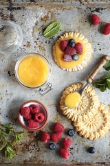 Lemon tartlets with lemon curd and fresh berries. Overhead view