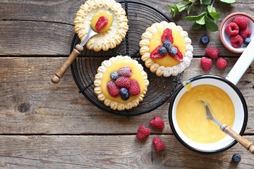 Lemon tartlets with lemon curd and fresh berries. Overhead view