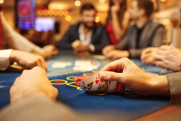 People play poker at the table in the casino. - obrazy, fototapety, plakaty