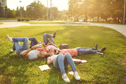 Young People Are Laughing While Lying On The Grass