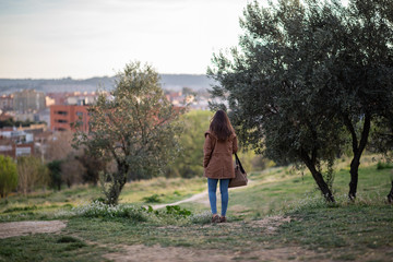 Beautiful woman standing on park during sunset