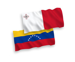 National vector fabric wave flags of Venezuela and Malta isolated on white background. 1 to 2 proportion.