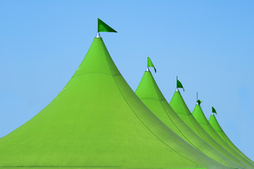 green canvas event tents against blue sky