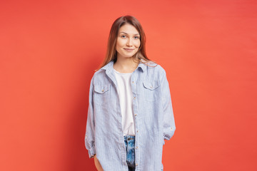 Pretty female model posing with a smiling face expression on red background