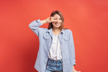 Funny, carefree girl having fun isolated on a red background
