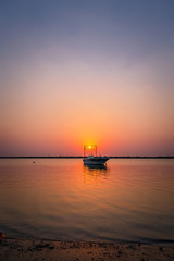 Fototapeta na wymiar Beautiful Sunrise Boat in seaside with red and dark sky. Dammam -Saudi Arabia