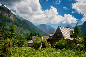 Summer landscape of Tatry mountains and woodan cottage.