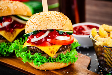 Tasty burgers with chips served on cutting board