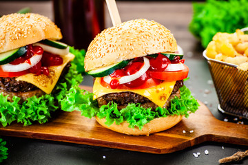 Tasty burgers with chips served on cutting board
