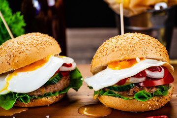 Tasty burgers with chips served on cutting board
