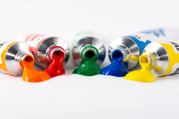 Gouache tube dripping paint and white background