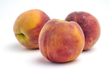 Several peaches isolated on white background.