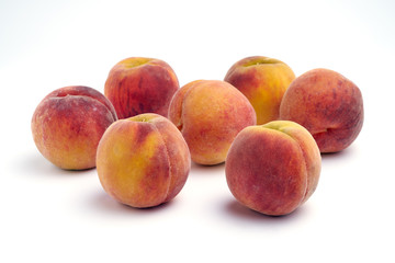 Several peaches isolated on white background.