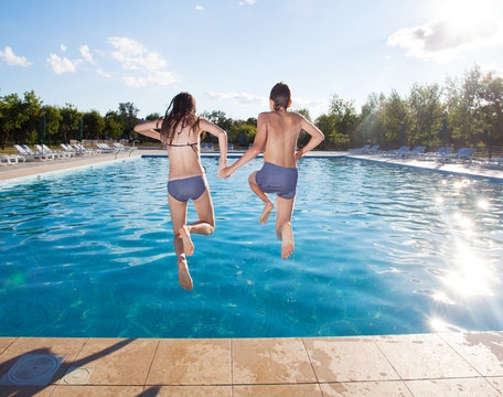 Couple jumping into pool