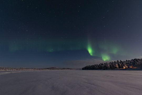 ooking across a frozen lake to the northern lights