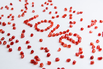 the word "love" from pomegranate seeds on a white background