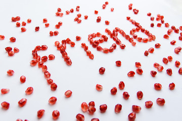 the word "friend" from pomegranate seeds on a white background