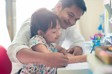 Obraz na płótnie Canvas Father helping her daughter for her homework