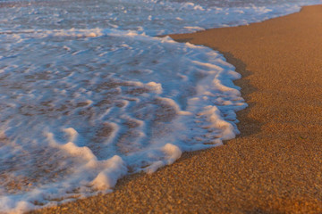 Foam from the sea water on the coast of the beach at sunset day