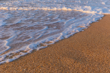 Foam from the sea water on the coast of the beach at sunset day