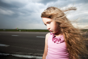 Sad child near road