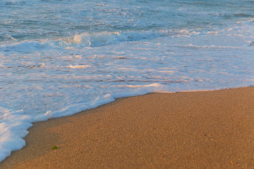 Foam from the sea water on the coast of the beach at sunset day