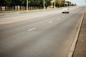 Fototapeta na wymiar urban car asphalted road in defocus, street without people, transport in the city