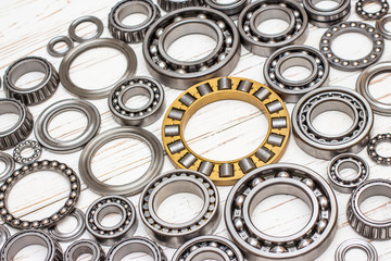 Bearings of all kinds and classifications on a white wooden background.