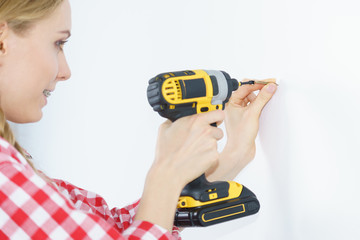 Woman drilling in wall