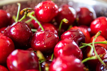 Fresh organic sweet cherries in a metal bowl for washing
