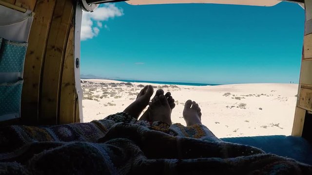 Romantic people inside old van for love concept and alternative lifestyle and vacation with vehicle camper - beach and ocean view luxury - enjoying nature and outdoors - wanderlust life