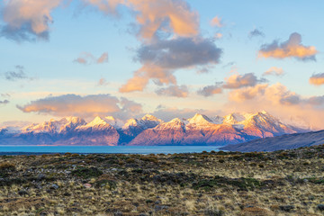 Beautiful dawn golden orange light of sun rise over the snow mountain with deep blue lake in the...