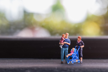 Miniature people : Parents with children walking outdoor , Happy family concept