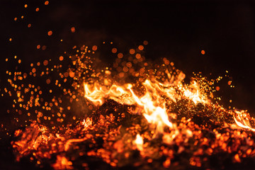 Burning red hot sparks fly from big fire. Beautiful abstract background on the theme of fire....