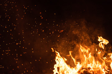 Burning red hot sparks fly from big fire. Beautiful abstract background on the theme of fire....