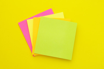 Colorful paper stickers on yellow background, blank note papers 