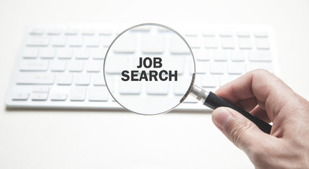 Hand holding magnifying glass. Job search