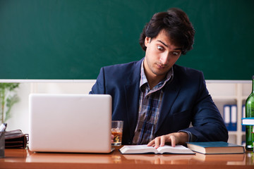 Male teacher drinking in the classroom 