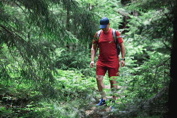 man hiker walking by forest trail. summer time