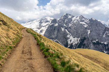 Mountain trail with a view of the Marmolada massif. Dolomites. Italy.