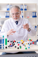 Old male chemist working in the lab 