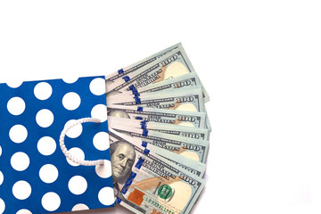 Isolated 100 US dollars banknotes bills are coming out of a blue paper bag on white background. Shopping sales concept. Copy space place for text