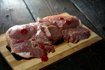  raw steak on bamboo cutting board, on old wooden background layout