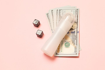 Dollar bills with dices and lubrication on a pink background. Sex for money.