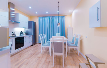 Fototapeta na wymiar Interior. Kitchen modern, light yellow walls, blue curtains