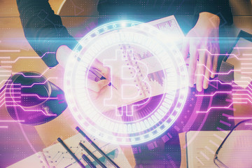 Cryptocurrency hologram over woman's hands writing background. Concept of blockchain. Double exposure