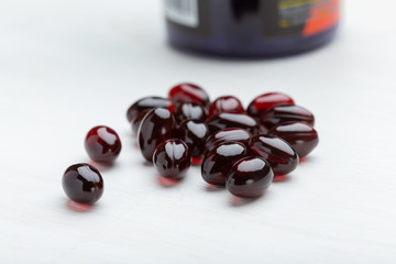 Red pills on a white table background. Concept of medication of vitamins and microelements. Treatment and prevention.