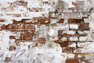 old shabby damaged plaster on the brick walls of houses close-up