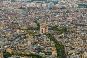 Lovely aerial view of the Arc de Triomphe de l'Étoile and the cityscape of Paris. Streets are leading to the roundabout of which the monument is the centre and concentration of traffic arises.