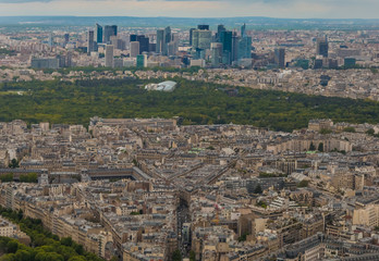 Fototapeta na wymiar Unique aerial cityscape panorama of the western edge of the 16th arrondissement of Paris. The Bois de Boulogne, a large public park & the skyline of La Défense, a major business district, can be seen.